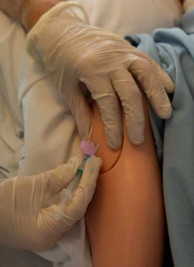 Een deelnemer injecteert subcutaan tijdens de toets verpleegtechnische handelingen